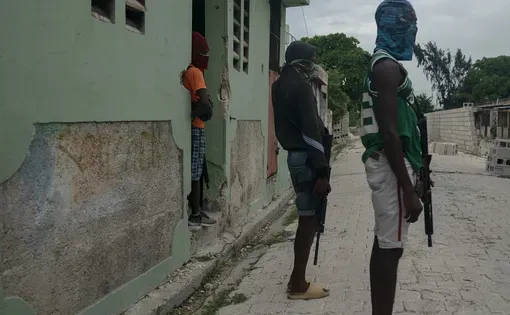 Armed teenage soldiers stand guard over Jimmy Chérizier in Port-au-Prince in October 2023. Better known as “Barbecue,” Chérizier now leads the Viv Ansanm gang coalition and is the subject of a $5 million US bounty.