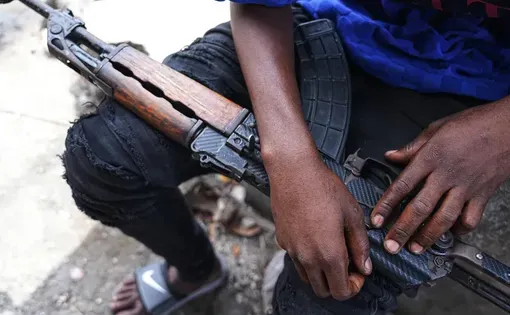 A member of the "Vivre Ensemble" ("Live Together") gang shows his rifle in Port-au-Prince, the capital of Haiti, on 21 February, 2026. Image by David allignon/ZUMA Press Wire via Reuters Connect. Haiti.