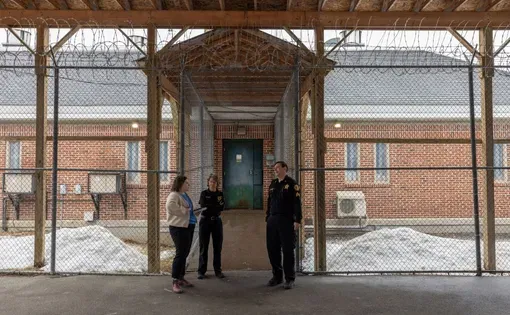 Reporter Emily Bader speaks to correctional officers outside of Piscataquis County Jail