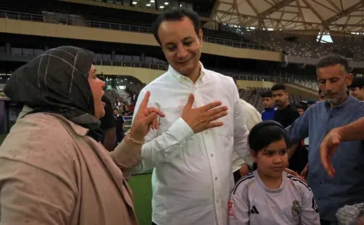Belgacem Haftar (center), director general of the Libyan Development and Reconstruction Fund (LDRF), speaks with a woman during his visit to the Benghazi International Stadium on May 22, 2026. / ABDULLAH DOMA / AFP