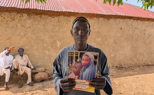 A man who lost two of his children to the Tudun Biri drone attack displaying the obituary pamphlet of his loved kids. Photo: Ibrahim Adeyemi/HumAngle.