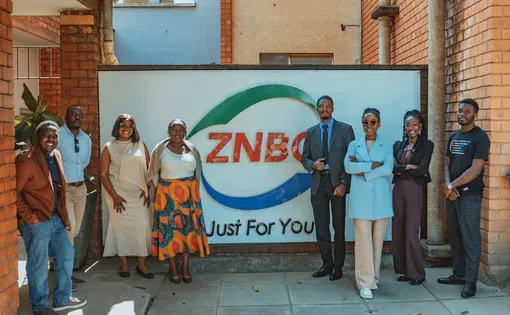 Radio participants stand in front of ZNBC sign