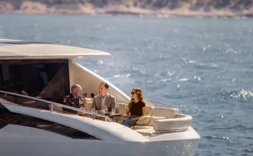 AI Image: a man and a woman sit on the back of a yacht in the water with another man in a general's uniform