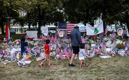 People walk in front of a memorial for slain conservative commentator Charlie Kirk, at Utah Valley University in Orem, Utah, on September 29, 2025.