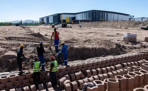 Workers construct a holding wall at a development site in the Atterbury King Air Industria area near the Cape Town International airport, 01 September 2026.