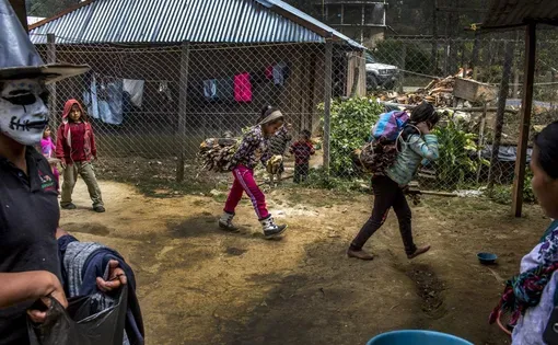 When men leave to find work in the United States, their tasks at home, like carrying wood, are left to wives and children, like these in Bulej, Guatemala. Image by Simone Dalmasso / For the Arizona Daily Star. Guatemala, 2019.