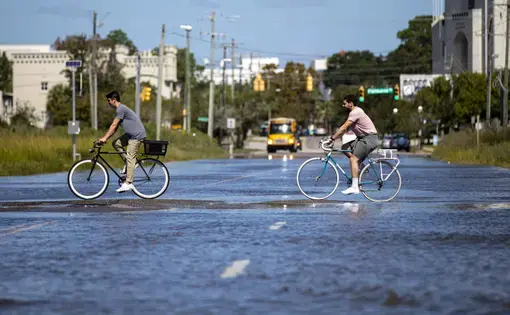 Bicyclists pedal through floodwater at the intersection of Hagood Avenue and Line Street on Monday, Sept. 21, 2020, in Charleston. Image by Andrew J. Whitaker / Post and Courier. United States, 2020.