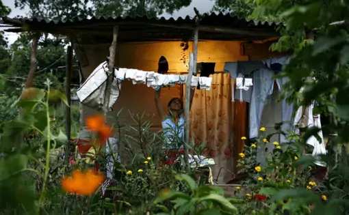 Nov. 15, 2006-- A woman folds clean laundry outside a squatter shack in the rural town of Montleban where dozens of families are protesting on private land in a demand for government housing assistance. 1