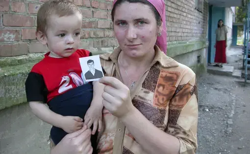 A woman in Sernovodsk, Chechnya, holds a picture of her brother, allegedly killed by Russian security forces in 2004. Image by Tom Parfitt, Chechnya, 2004.