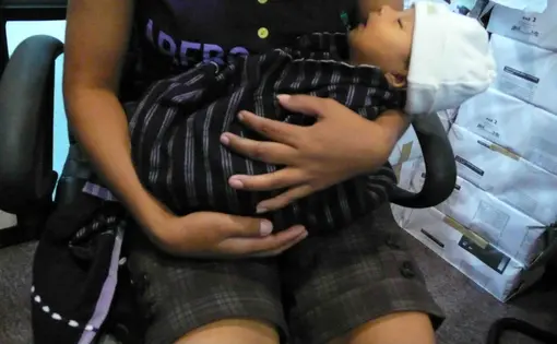 Su Su, a refugee from Burma, holds her 4 week old baby one week after they both were released from detention.