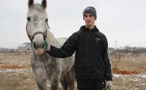 Ozdemir Tsipinov, 19, holds Makhosh, the horse thatbelonged to his father, Aslan Tsipinov, 51, who was murdered by Islamist gunmen on December 29, 2010, in Shalushka village, near Nalchik, in the Russian republic of Kabardino-Balkaria. Image by Tom Parfitt. Russia, February 2011.