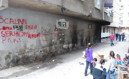 A group of kids playing in Baglar, beside PKK graffiti. Image by Jenna Krajeski.