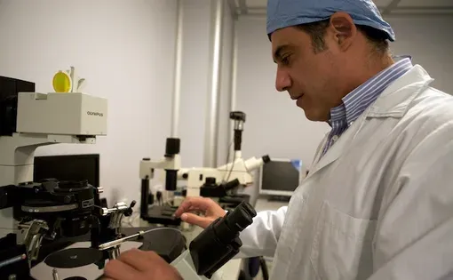 Savvas Koundouros looks through a microscope at the Genesis clinic in Limassol, Cyprus.