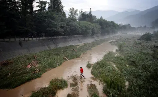 A man walks through one of the drainage channels that make up the Dujiangyan Irrigation system. China. Sean Gallagher, 2010