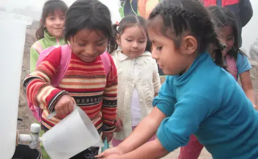 Children at the Santa Rosita Kindergarten, in the Huaycan shantytown on the eastern outskirts of Lima, use water brought by their parents in buckets to wash their hands. Image by Simeon Tegel. Peru, 2012. Media file: Waterless Lima 019.JPG