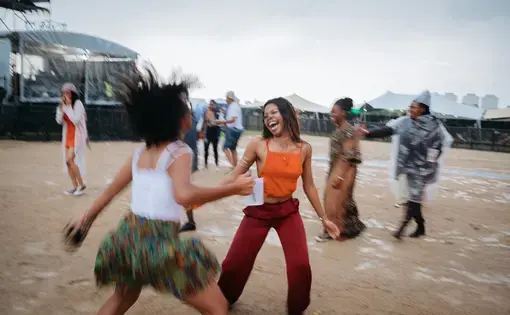 Rain can't dampen the spirits of Afropunk Joburg attendees. They continue to dance as rain begins to fall in Johannesburg in December. Image by Melissa Bunni Elian. South Africa, 2017.