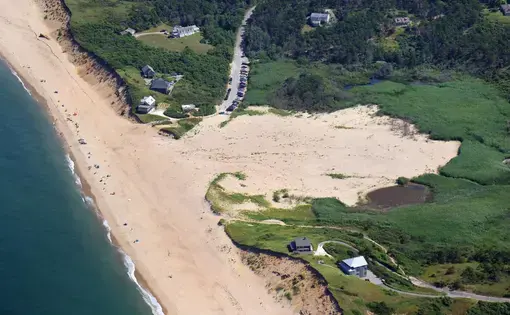 Ballston Beach from the air looks a bit like a battle scar, the dunes flattened by frequent storms. Image by John Tlumacki. United States, 2019.