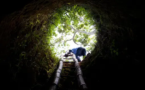 A teenage boy climbs out of a gold mine in Northern Haiti. People in this village have been digging for gold since the 1960s. With the increase in gold prices over recent years American and Canadian gold companies have a renewed interest in Haiti and are busy scouring northern Haiti for deposits. Image by Ben Depp. Haiti, 2012. Media file: bd-gold-41.jpg
