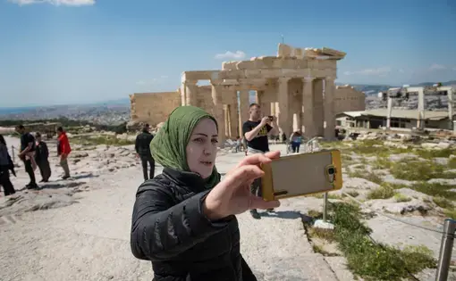 Syrian refugee, Taimaa, shoots a selfie while visiting the Acroplis in Athens. Image by Lynsey Addario. Greece, 2017.