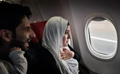 Syrian refugees Taimaa Abzali and her husband Muhanned Abzali, look out the window with a mix of fear and excitement as they see Estonia from the air for the first time. Image by Lynsey Addario. Estonia, 2017.