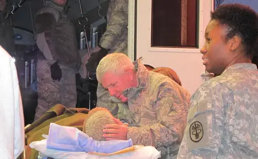 Maj. Brian Knutson, a Oregon Air National Guard chaplain, greets a wounded soldier arriving at Landstuhl Regional Medical Center from Afghanistan. Image by Meg Jones. Germany, 2010.