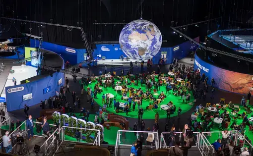 A globe rotates high above a room of the Scottish Event Center where COP26 was held.