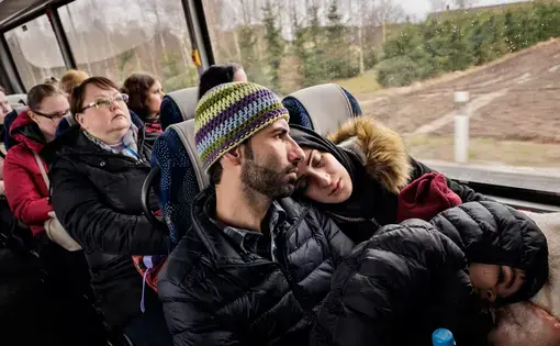 Syrian refugees Taimaa Abzali and her husband Muhanned Abzali, and their six month old daughter, Heln, and son Wael, take the bus in the early morning in the sleet and snow as they make their way to their orientation with IOM on their second full day in Estonia. Image by Lynsey Addario. Estonia, 2017.