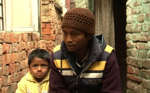 Rajan Kumar Nepali sits with his daughter in his house in Ranibari, Kathmandu. He said his daughter was wrongfully placed for adoption with an American family who were getting ready to take her to the United States. Image by Anup Kaphle. Nepal, 2011.