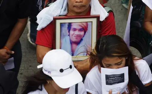 A father of a slain drug suspect clutches a photograph of his late son at a rally in Quezon City, on July 24, 2017. Image by Pat Nabong. Philippines, 2017.