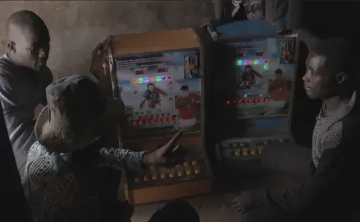 Villagers gamble at the Chinese machines in a roadside shack in Zamashegu. Image by Noah Fowler. Ghana, 2017.