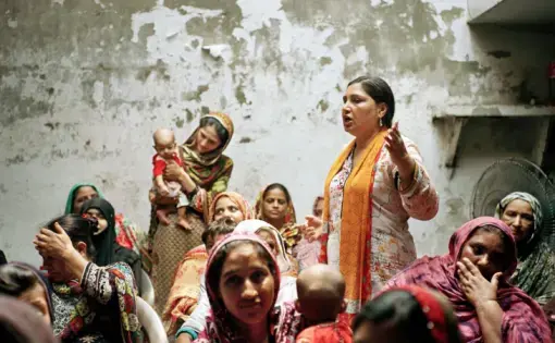 Days before Pakistan’s general elections, 50-year-old activist and human rights defender Bushra Khaliq encouraged rural women to vote. A longtime campaigner for women’s rights and labor rights, Khaliq has survived social and state-level attacks on her work. In 2017, the Ministry of Interior and home department of Pakistan accused Khaliq’s organization of performing “anti-state activities.” Khaliq took her case to the Lahore High Court and won the right to continue working. Image by Sara Hylton/National…
