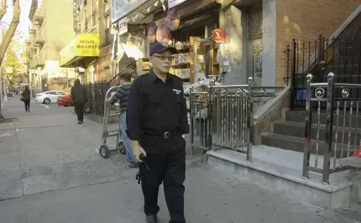 Chen Jihua, an auxillary policeman in New York, patrols in Brooklyn. He didn't see his daughter for 16 years after being smuggled into the U.S. by Chinese snakeheads. Image by Rong Xiaoqing. United States, 2016.