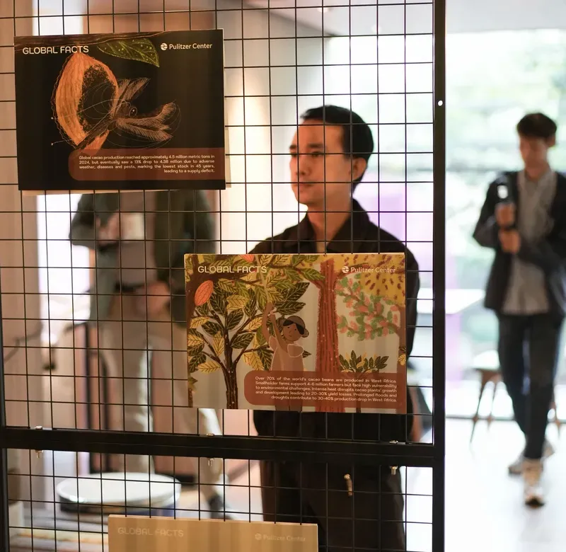 a man views a painting in a dark-lit gallery