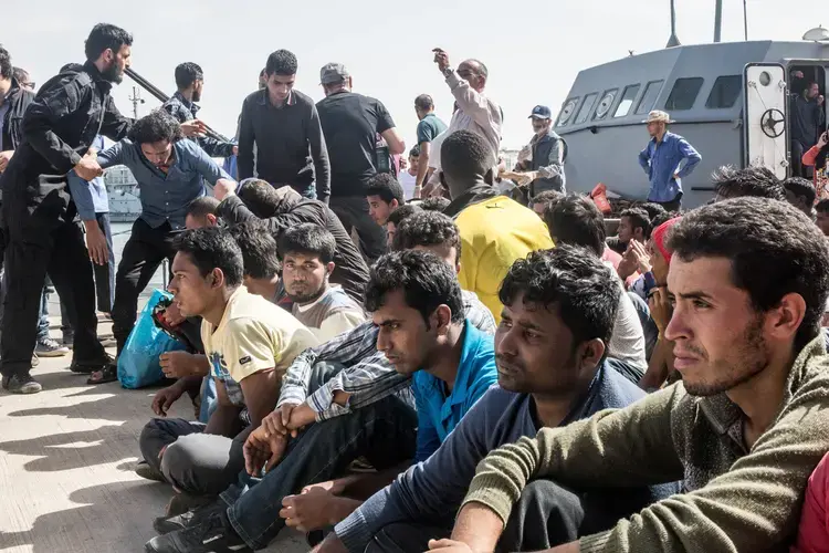 Migrants from Bangladesh and Morocco disembark a warship operated by the Libyan navy after their boat was intercepted at sea. Image by Peter Tinti. Libya, 2017.