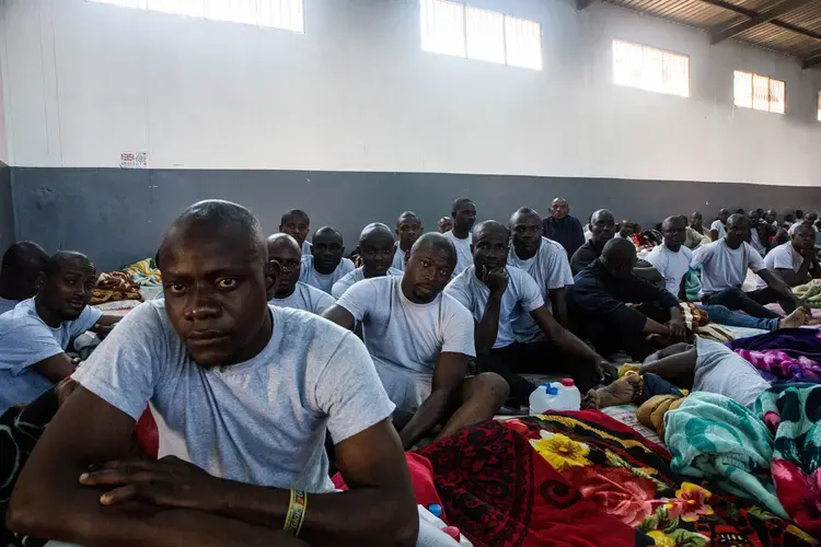Nigerian migrants inside a locked hangar at the Airport Road detention center in Tripoli, where they had been held for more than a month. Image by Peter Tinti. Libya, 2017.