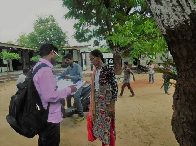 Health coordinator Ajay Vaghela and health worker Modi Niven compare notes at one of the local Manav Sadhna schools. Image by Ambar Castillo. India, 2017.