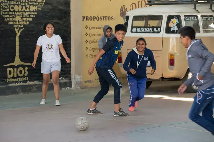 Young people play soccer at Villa Galindo Baptist Church in Cochabamba. Some children go to the church on weekends while their parents work. Others come from San Sebastian prison, which is overcrowded and has no playground. 'Soccer, jumping around, it's part of letting off steam,' Pastor Alex Villarroel said. Image by Tracey Eaton. Bolivia, 2017.