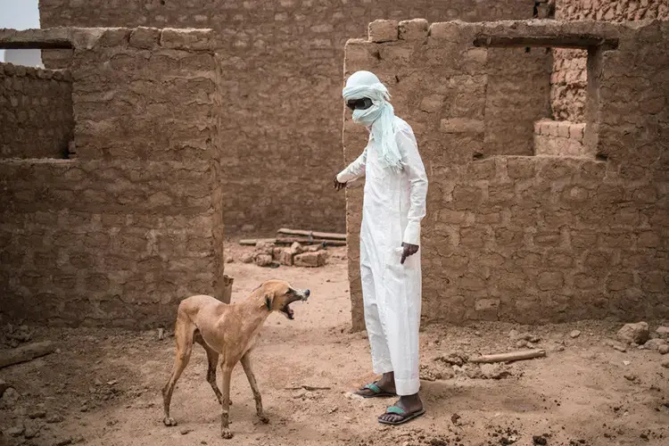 Mohamed stands in the ruins of his old house, out of which he used to run a lucrative migrant ghetto. Image by Nichole Sobecki. Niger, 2017.