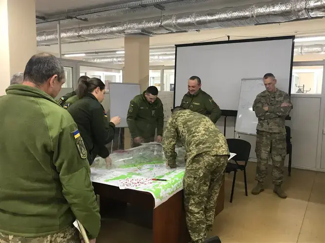 Wisconsin National Guard Col. John Oakley, at right, watches Ukrainian soldiers prepare for a war game at a combat training center in western Ukraine. Oakley is commander of a unit of 164 Wisconsin soldiers who are mentoring Ukrainian military trainers. Image by Meg Jones / Milwaukee Journal Sentinel. Ukraine, 2020.