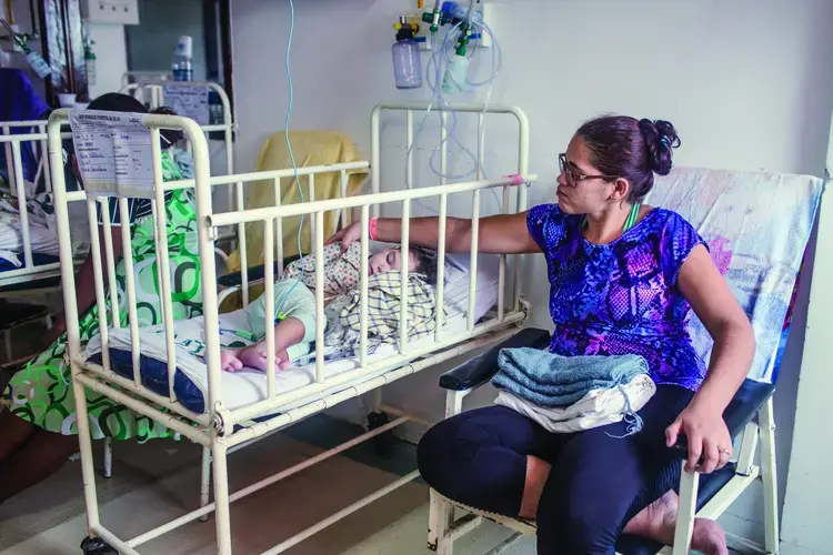 Mylene Helena dos Santos Ferreira and her son Davi wait in the hospital to speak with a doctor. Image by Fábio Erdos. Brazil, 2017.