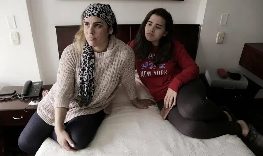 Lisset López Rodríguez (left) and her daughter Camila Guzmán López in their tiny hotel room in Bogota, Colombia as they wait for an interview date at the U.S. Embassy in Bogota. Since the reduction of staff at the U.S. Embassy in Havana because of health attacks against diplomats, Cubans that were in the process of getting permanent visas for their family members to travel to the United States now have to go to Bogota, Colombia to complete the process. Image by José A. Iglesias. Colombia, 2017.