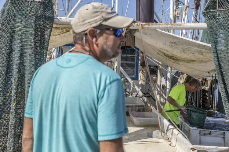 Roscoe Liebig, left, and Eldon Kruse, right, at Pass Christian Harbor. Image by Eric J. Shelton for Mississippi Today. United States, 2019.