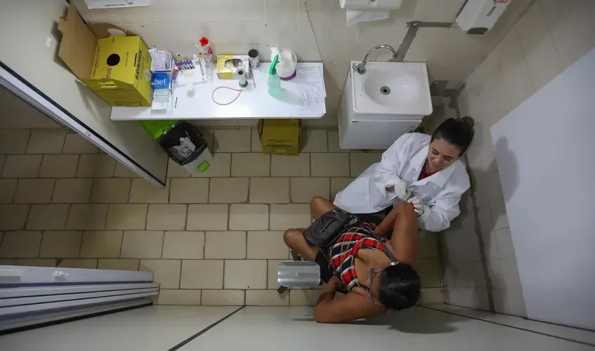 Erika Jorge, a member of the Laboratory of Dermatology-Immunology, takes skin samples from the elbow of a 60-year-old woman who had been exposed to leprosy. Image by Anton L. Delgado. Brazil, 2020.