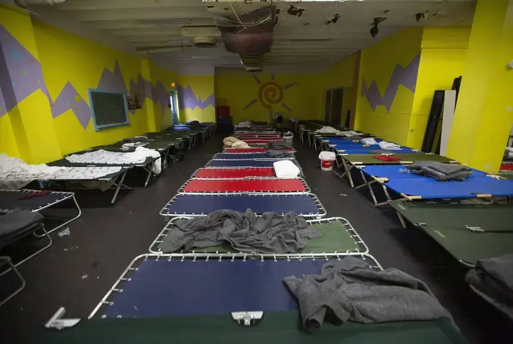 Cots are set up inside the Travis Park Church in downtown San Antonio, where an influx of migrants, mostly from Africa, have been arriving in large numbers. Volunteers from the Interfaith Welcome Coalition help run the shelter. Image by Marjorie Kamys Cotera. United States, 2019.