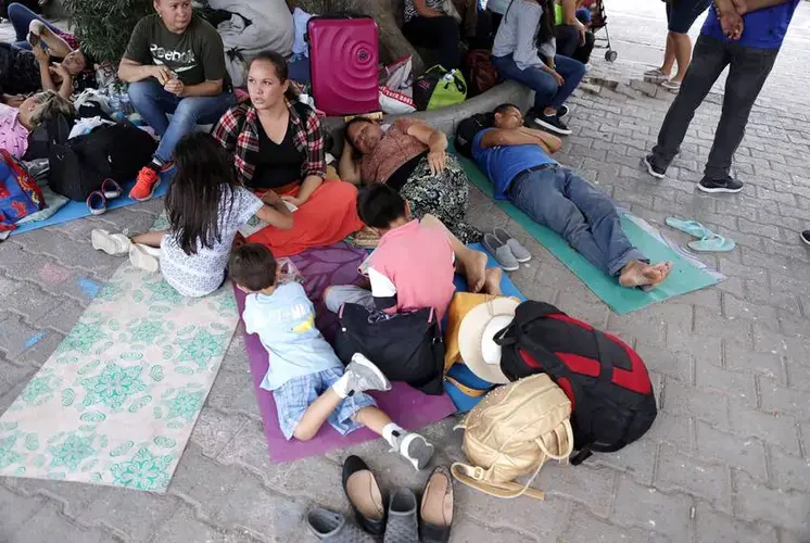 Migrants who are waiting to claim asylum in the United States gather near the entrance of the Gateway International Bridge in Matamoros, Tamaulipas. Image by Miguel Gutierrez Jr. Mexico, 2019.