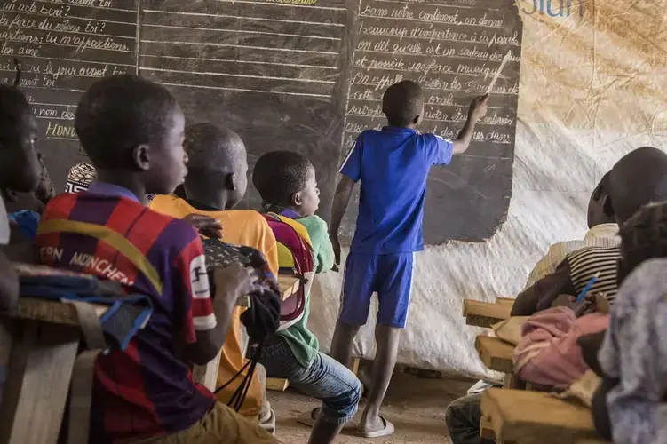 Children attend a class at a temporary-learning space run by UNICEF in a camp for displaced people in Kaga Bandoro, a rebel-held town in CAR. “Children are paying the highest price for this new surge of violence,” a UNICEF director says. Image by Jack Losh. Central African Republic, 2018.