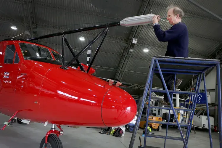 Tom Lachlan-Cope of the British Antarctic Survey cleans and double-checks meteorological instruments on the aircraft. Image by Ari Daniel. Iceland, 2018.