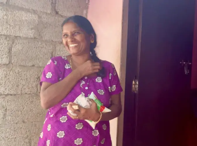 Sali, a resident in Chathanad Colony, carries groceries into her home. Image by Katelyn Weisbrod. India, 2019.