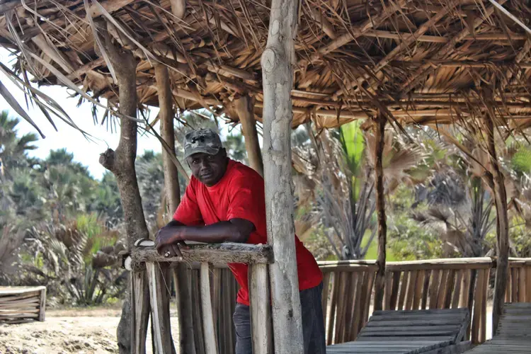 Lamin Jammeh looks out onto the North Atlantic Ocean. The environmental activist is head of Environmental Concern Group Gunjur which, along with other local groups, has brought a civil lawsuit against Golden Lead fishmeal factory on behalf of residents. Image by Nosmot Gbadamosi. The Gambia, 2018.