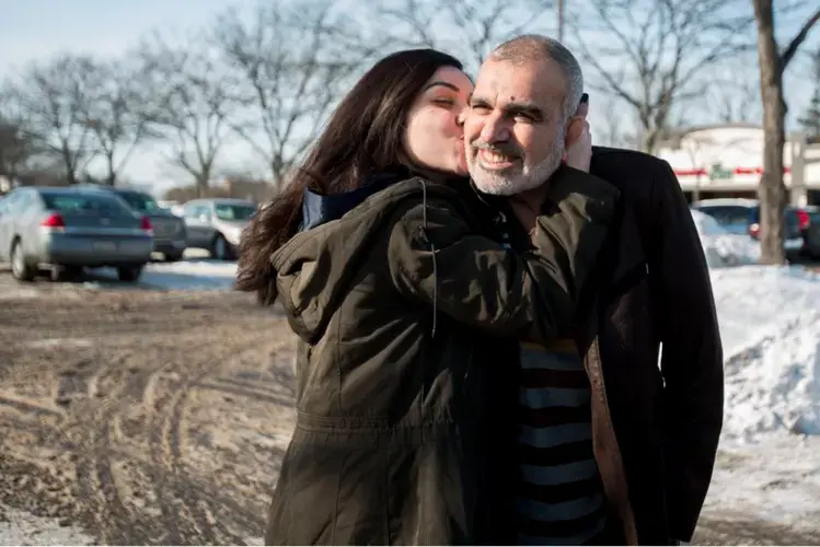Zahra Ahmad kisses her father, Mohammad Ahmad Sibte, whom she calls Baba, on the cheek before departing to Iraq from Detroit on Feb. 1, 2019. Zahra's parents, Mohammad Ahmad Sibte and Lamiya Adil Mahdi, survived the Irani-Iraqi revolution. Image by Brontë Wittpenn. United States, 2019.